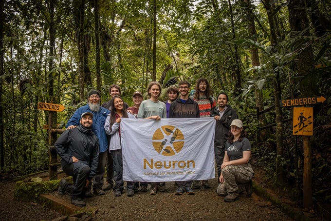 Members of a Neuron Expedition with the foundation's flag in the field