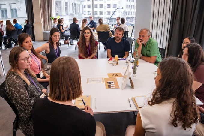 Students at a table with a scientist at a Neuron Junior event